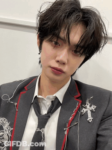 Young Man In Suit And Tie With Cross GIF