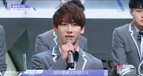 Young Man In Suit Holding Microphone GIF