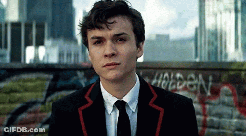 Young Man In Suit In Front Of Holden Wall GIF