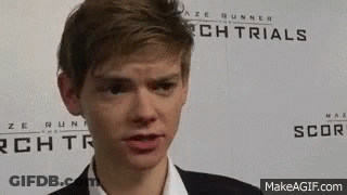 Young Man In Suit In Front Of Maze Runner Sign GIF