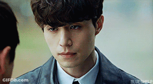 Young Man In Suit Looking At Another Man's Face GIF