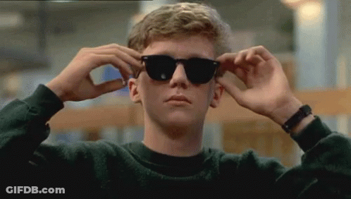 Young Man In Sunglasses Adjusts Glasses GIF