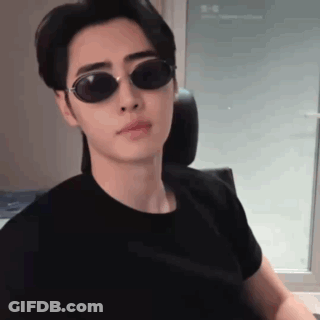 Young Man In Sunglasses And Black T-Shirt Sitting In Chair GIF