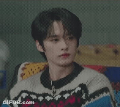 Young Man In Sweater Smiling On Couch GIF
