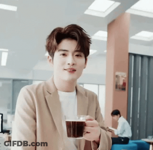 Young Man In Tan Jacket Holding Coffee GIF