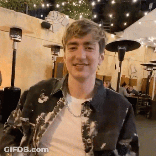 Young Man In Tie Dye Jacket And Chain GIF