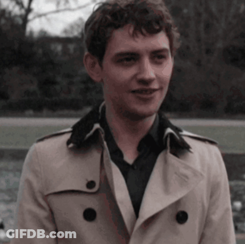 Young Man In Trench Coat And Black Shirt Smiling GIF
