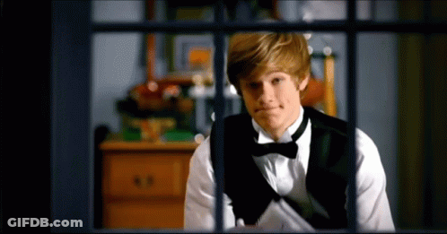 Young Man In Tuxedo Looking Out Window GIF