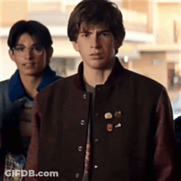 Young Man In Varsity Jacket Standing In Line GIF