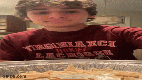 Young Man In Virginia Tech Shirt Standing By Pan Of Food GIF