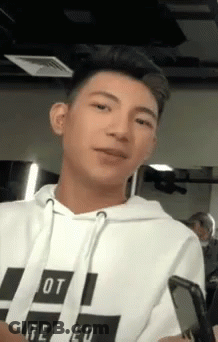 Young Man In White Hoodie Holding Cell Phone GIF