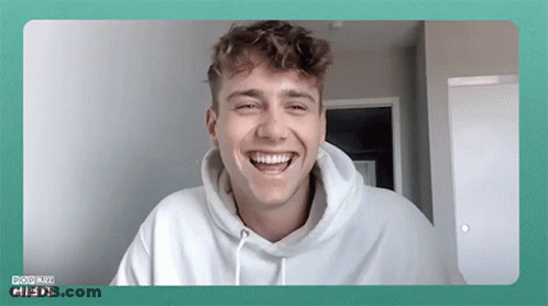 Young Man In White Hoodie Laughing At Camera GIF