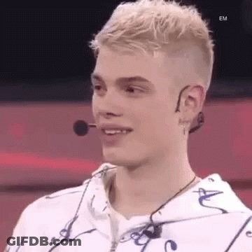 Young Man In White Hoodie Smiling With Microphone GIF