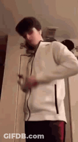 Young Man In White Jacket Holding Cell Phone GIF