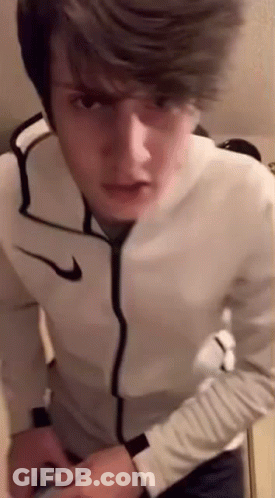 Young Man In White Nike Jacket Standing In Front Of Mirror GIF