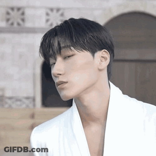 Young Man In White Robe Looking At Camera GIF