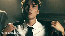 Young Man In White Shirt And Black Tie Adjusting Jacket GIF