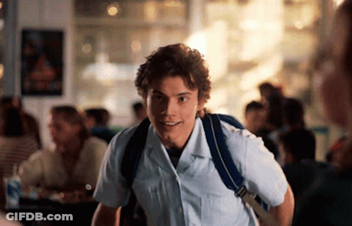 Young Man In White Shirt And Blue Backpack Smiling GIF