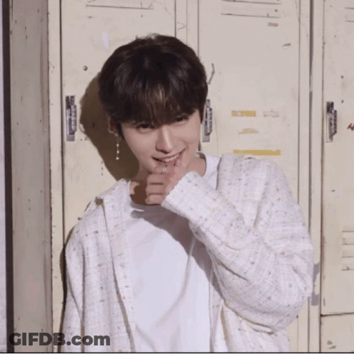 Young Man In White Shirt And Cardigan In Front Of Lockers Smiling GIF