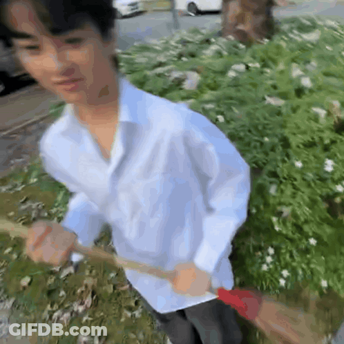 Young Man In White Shirt Holding Broom GIF