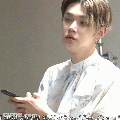 Young Man In White Shirt Holding Cell Phone GIF