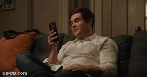Young Man In White Shirt Holding Cell Phone GIF