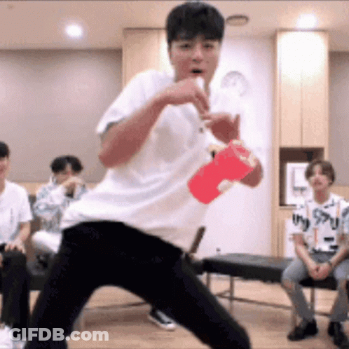 Young Man In White Shirt Holding Red Cup GIF