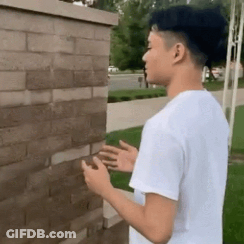 Young Man In White Shirt Looking At Phone GIF