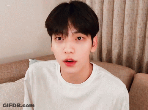 Young Man In White Shirt On Couch Looking At Camera GIF