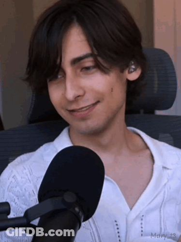 Young Man In White Shirt Smiling At Microphone GIF