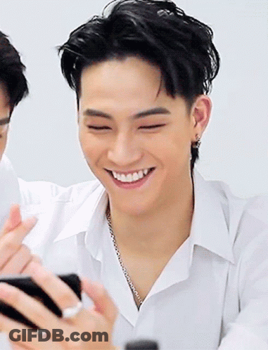 Young Man In White Shirt Smiling Holding Cell Phone GIF