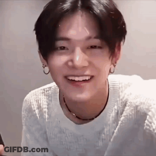Young Man In White Sweater And Black Necklace Smiling GIF