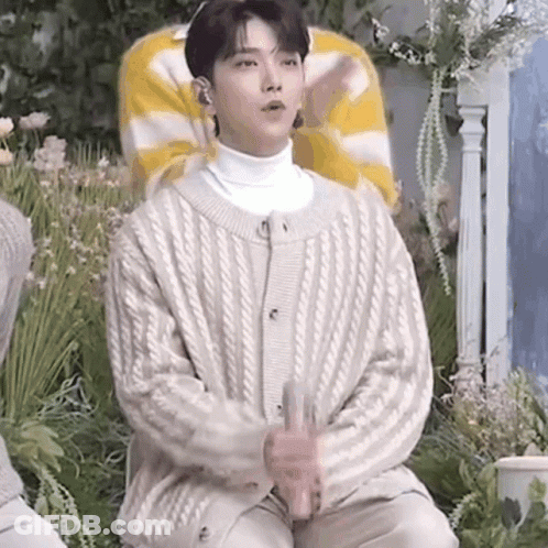 Young Man In White Sweater Holding Glass GIF