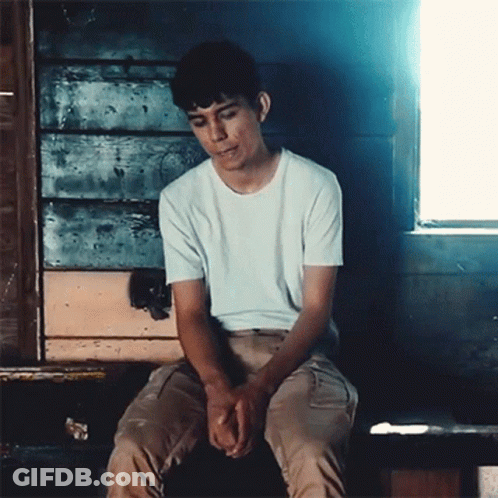 Young Man In White T-Shirt On Bench By Window GIF