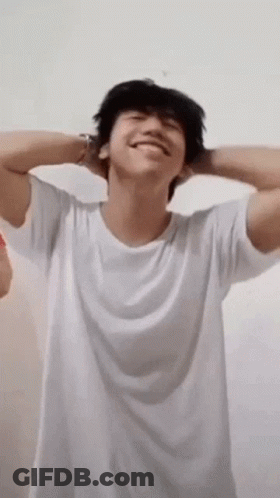 Young Man In White T-Shirt With Hands Behind Head GIF