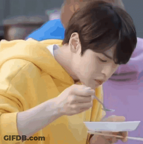 Young Man In Yellow Hoodie Eating With Chopsticks GIF