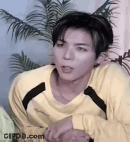 Young Man In Yellow Shirt Sitting GIF