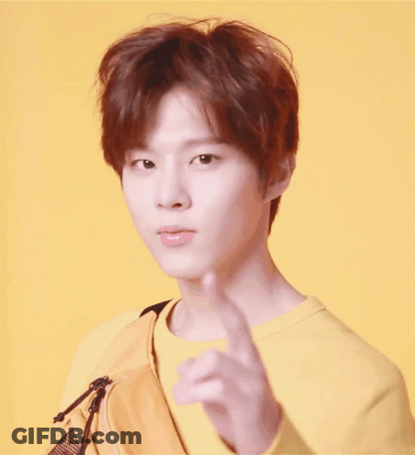 Young Man In Yellow Sweatshirt And Bag Pointing GIF