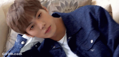 Young Man Laying On Couch In Denim Jacket GIF