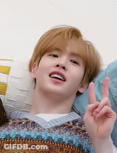 Young Man Laying On Couch Making Peace Sign GIF