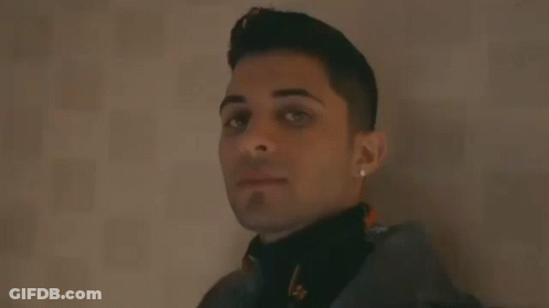 Young Man Leaning Against Wall Smiling GIF