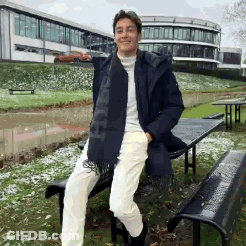 Young Man Leaning On Bench In Front Of Building GIF