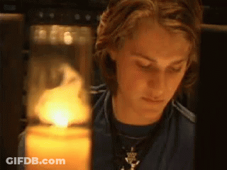Young Man Looking At Lit Candle GIF