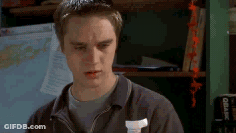 Young Man Making Funny Face In Front Of Map Shelf GIF