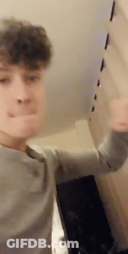 Young Man Making Funny Face In Front Of Wall GIF