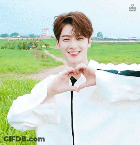 Young Man Making Heart With Hands In Field GIF