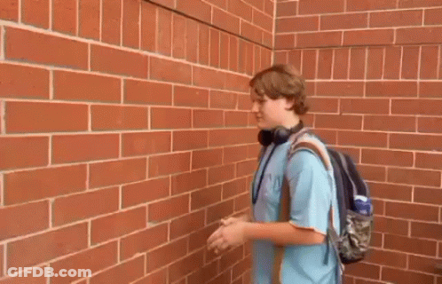 Young Man Outstretched Hands Brick Wall GIF