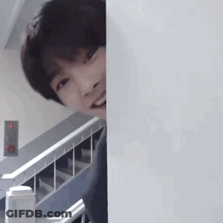 Young Man Peeking Behind Wall GIF