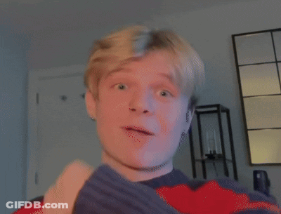 Young Man Pointing Up In Red And Blue Sweater GIF