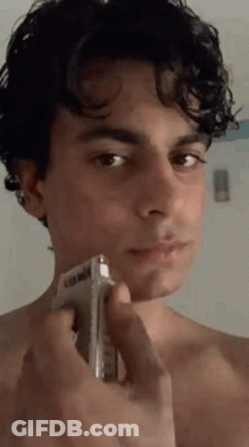 Young Man Shirtless Shaving Face With Razor GIF